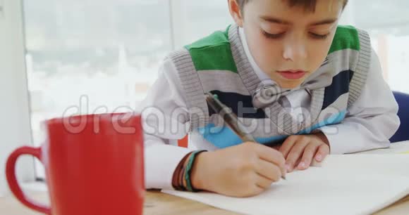 小男孩书写笔记的特写视频的预览图