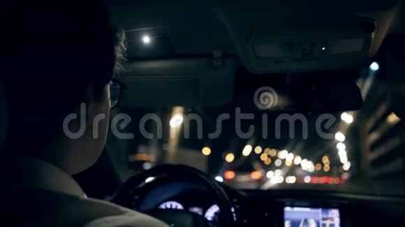一个商人开着一辆车穿过一条夜间隧道的后视镜视频的预览图