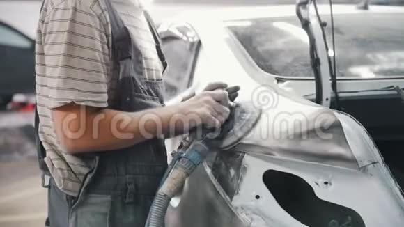 机械师用磨床把油漆过的车身磨碎视频的预览图