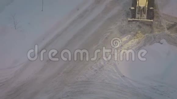拖拉机从雪地上清理院子里的道路拖拉机清理雪刷视频的预览图