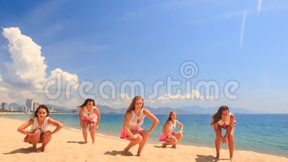 啦啦队员在沙滩上与大海做深蹲表演视频的预览图