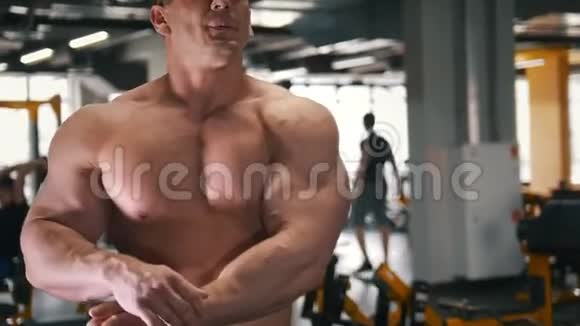 肌肉强壮的健美运动员在镜子前赤裸的躯干在健身房视频的预览图