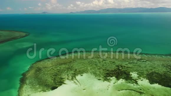 观赏神奇的珊瑚礁无人驾驶飞机在宁静的蓝海和美丽的珊瑚礁海岸附近的图片景观视频的预览图