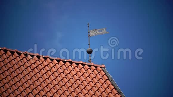 晴天蓝天背景下红瓦屋顶上的风向标视频的预览图