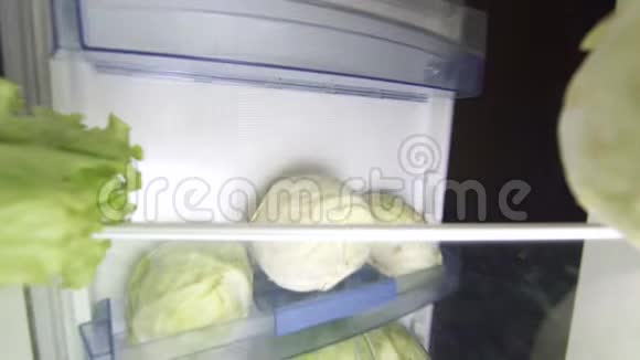 40岁的节食妇女晚上打开冰箱看一份绿色沙拉视频的预览图