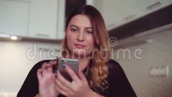 漂亮的年轻女孩用智能手机和微笑打电话给她的女朋友家风视频的预览图