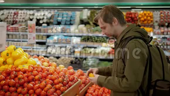 年轻人在蔬菜商店或超市里买番茄食品视频的预览图