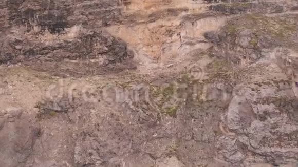一群山山羊在陡峭的山上奔跑的空中镜头视频的预览图