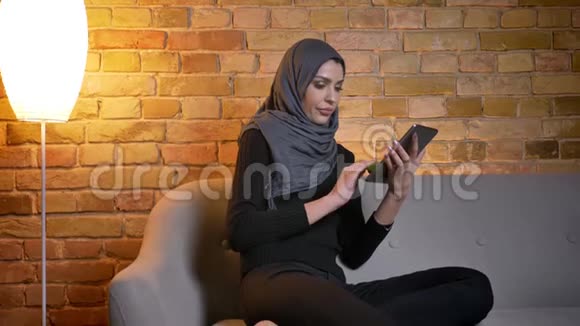 用平板电脑拍摄成年穆斯林女性迷人的头巾并在应用程序上显示绿色彩色屏幕视频的预览图