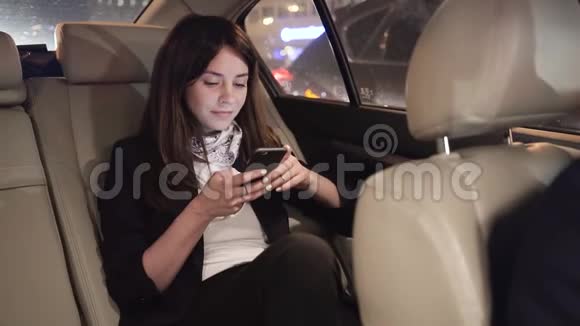 女商人在车里看智能手机时微笑着视频的预览图