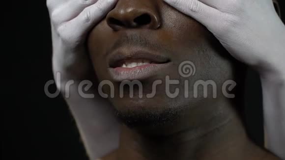 一个坚定的黑人男子从他的眼睛里移开白人女人的手视频的预览图
