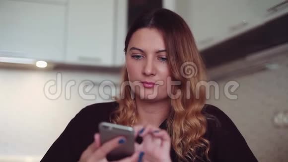 一个漂亮的年轻女孩在她的智能手机和手机上拨打电话号码家风视频的预览图