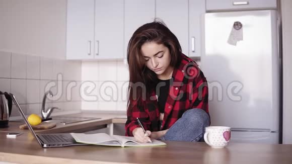 年轻漂亮的女孩正在写一些东西她在笔记本电脑上发现了一些东西视频的预览图