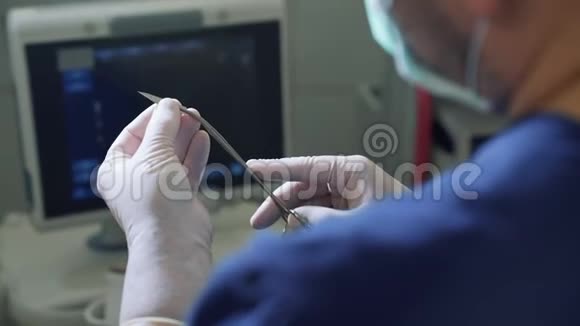 个人视角医生戴无菌手套将手术刀刀片握在手术前夹钳中POV关闭视频的预览图