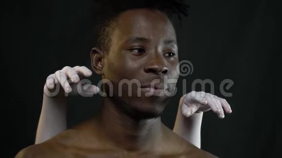 黑人男子把女孩双手放在白色的身体艺术中假装这是耳机视频的预览图