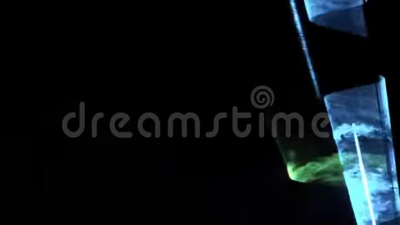 激光表演抽象的绿色和蓝色光线透过烟雾在黑暗的背景上发光视频的预览图