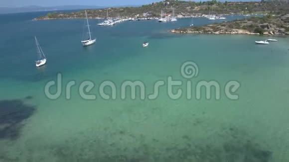 在希腊哈尔基迪基的Panagia湾用游艇码头俯瞰绿松石海用无人驾驶飞机前进视频的预览图