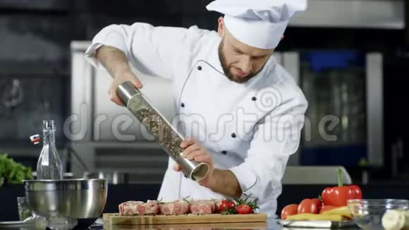男厨师在专业厨房煮肉厨师烹饪牛排的肖像视频的预览图