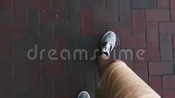 一个穿着短裤和蓝色运动鞋的旅行者走在铺路板上电视视频的预览图