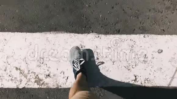 顶部景观蓝色运动鞋上沥青人行横道在城里散步的人视频的预览图