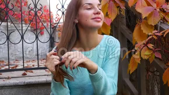 快乐的女人在秋天慢慢地扔树叶微笑着视频的预览图