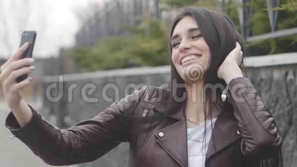 一张快乐的女人用智能手机自拍的照片视频的预览图
