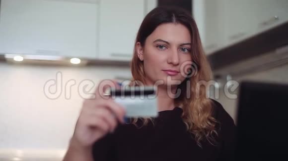 美丽的网上银行女性借助手机和信用卡心情愉快视频的预览图