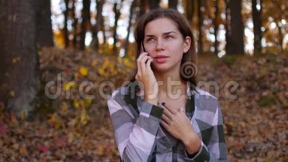 黄色森林里的女孩女人在秋林打电话视频的预览图
