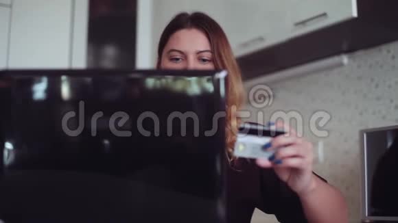 一个心情好的漂亮年轻女孩将信用卡信息输入在线商店视频的预览图