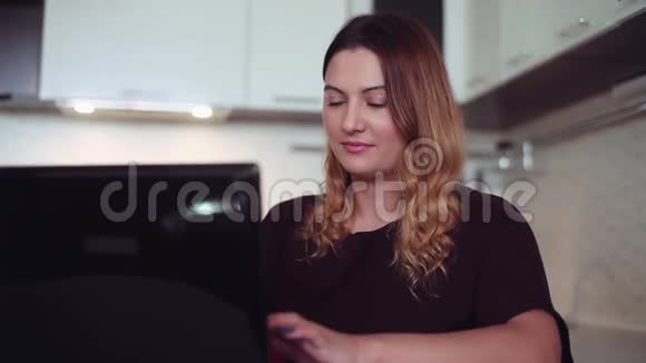 漂亮的年轻女孩正在笔记本电脑上打字家庭风格视频的预览图