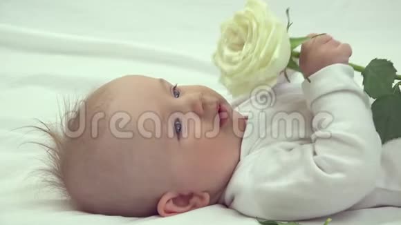 可爱的孩子的画像蓝眼睛捧着精致的纯白玫瑰视频的预览图
