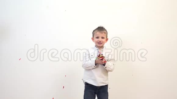 小男孩玩纸屑享受微笑跳舞视频的预览图