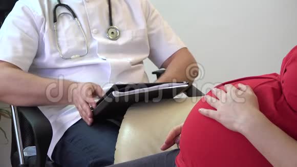 双手紧贴医生给孕妇做超声波图像抚摸腹部视频的预览图