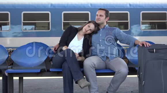 一对夫妇拥抱在火车站等待快乐的旅行新的生活男人和女人微笑视频的预览图