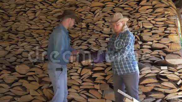 一个男人和一个女人把柴火放在树林里互相帮助视频的预览图