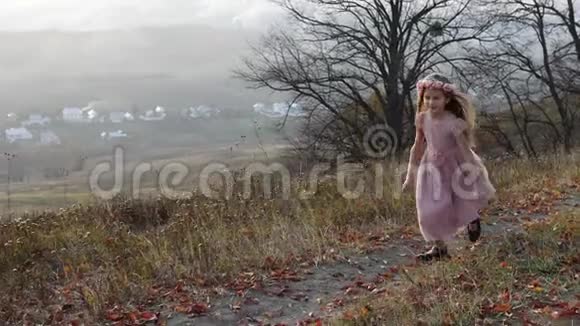 快乐可爱的女孩跑到山上背景上令人惊叹的风景视频的预览图