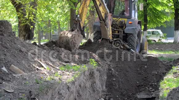 拖拉机站在地面坑附近反铲堆放地面特写视频的预览图