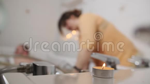 一个男人坐在医用浴油里一个在水疗中心的女员工从热水中得到按摩一种特殊的技术一种视频的预览图