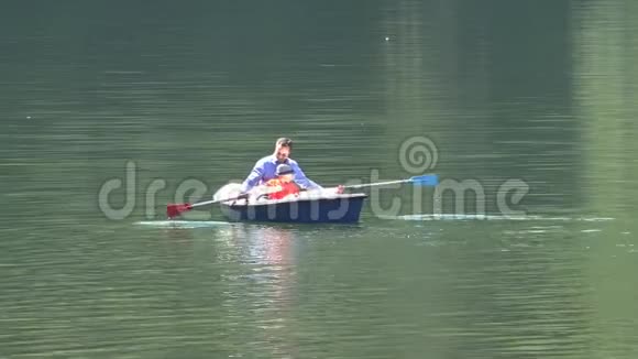 父亲和儿子在船上划桨孩子学会划桨美丽的湖一起度过时光珍贵的回忆视频的预览图
