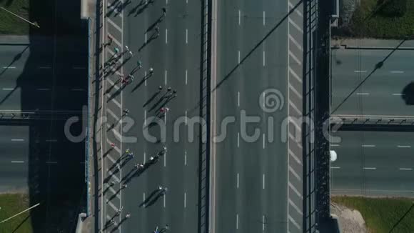 空中无人机镜头顶部景观马拉松跑在道路交叉口近距离射击视频的预览图