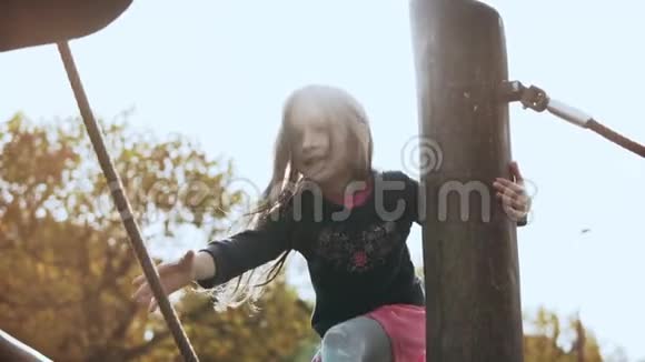 秀场上可爱的小女孩的肖像7岁的女孩微笑着越过绳索障碍慢动作视频的预览图