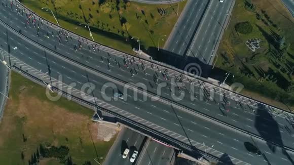 空中无人机镜头在公路交叉路口上跑马拉松视频的预览图