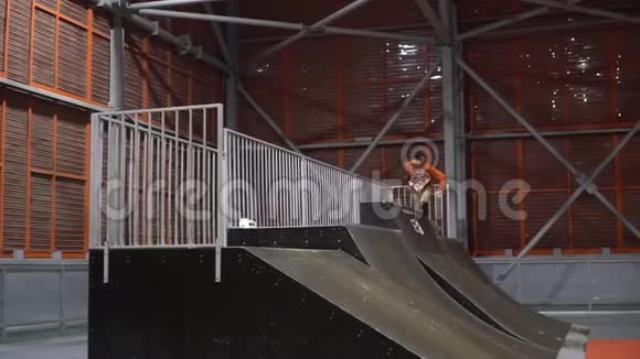 一个穿滚轴的人在斜坡上的栏杆上跳下来动作很慢视频的预览图