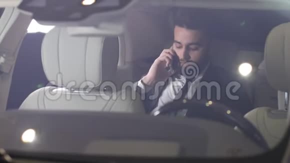 年轻的男商人在一辆豪华车上打电话视频的预览图