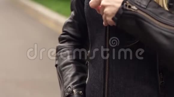 贴身女自行车手在皮夹克上系拉链视频的预览图