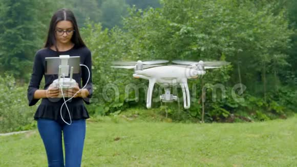 年轻女子用遥控发射器控制无人机视频的预览图