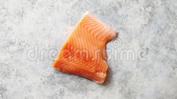 生的新鲜鲑鱼肉放在灰色的石头背景上视频的预览图