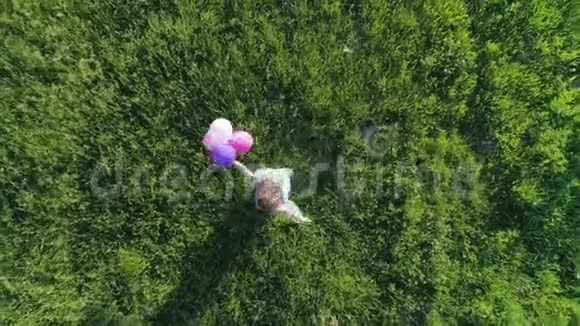 夏天留着彩色头发的少女正在草坪上玩气球视频的预览图