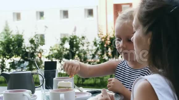 妈妈和她的小女儿在户外咖啡馆视频的预览图