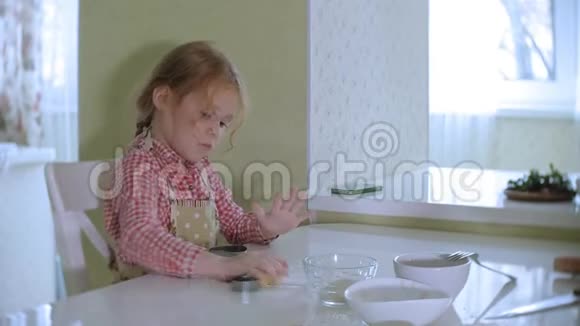 快乐的小女孩在家厨房里擀饼干面团视频的预览图